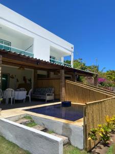 een achtertuin met een zwembad en een huis bij Ville Santorinni in Japaratinga