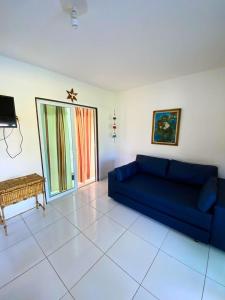 een woonkamer met een blauwe bank en een tafel bij Ville Santorinni in Japaratinga