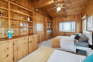 a log cabin bedroom with two beds and a ceiling fan at The Big Sky in Pearblossom