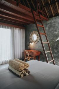 1 dormitorio con 1 cama con escalera y escritorio en Villa Amantes Bingin, en Uluwatu