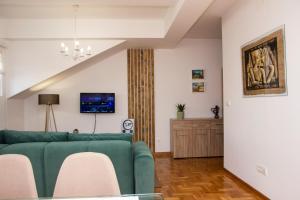 a living room with a green couch and a tv at Apartman MIA Centar in Kruševac