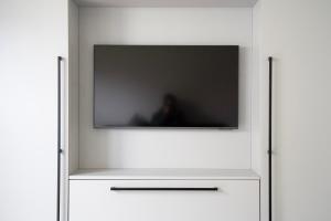 a flat screen tv sitting on top of a white cabinet at Haus Seeadler 2 EG in Dangast