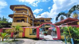 a yellow building with palm trees in front of it at Hotel Cielo Azul in Atacames