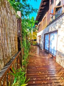 una pasarela de madera junto a un edificio con valla en Casa Iluminalia en Ilha Grande