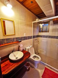 a bathroom with a toilet and a sink and a shower at Casa Iluminalia in Abraão