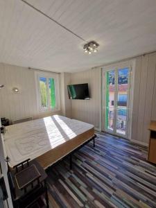 1 dormitorio con 1 cama grande en una habitación con ventanas en Appartement 2 chambres, rénové, climatisé, en Amélie-les-Bains-Palalda