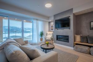 a living room with a couch and a tv and a fireplace at Lago 55 by Tremblant Platinum in Mont-Tremblant