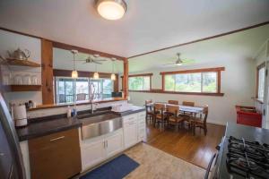 a kitchen with a sink and a table with chairs at Hana Homestead in Hana