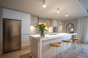 a kitchen with a counter with stools and a refrigerator at Lago 55 by Tremblant Platinum in Mont-Tremblant
