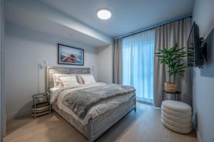 a bedroom with a bed and a large window at Lago 55 by Tremblant Platinum in Mont-Tremblant