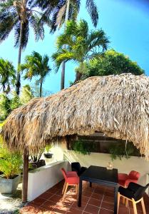 a resort with chairs and a straw roof at Villa de 2 chambres avec piscine privee jardin clos et wifi a Le Lamentin in Le Lamentin