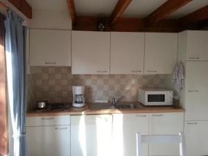 een keuken met witte kasten en een magnetron bij Ferienhaus Villa-Josefin in De Haan
