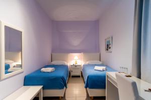 Cette chambre comprend 2 lits et un miroir. dans l'établissement Manto Hotel, à Mykonos