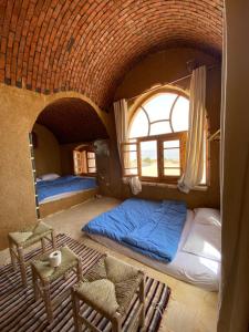 a bedroom with a bed and chairs in a room at Lala Land Camp in Nuweiba