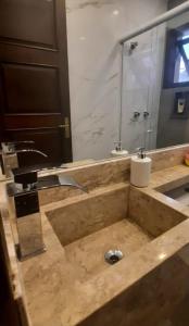 a bathroom counter with a sink and a mirror at Recanto de Itaipava - casa com forno de pizza a lenha, churrasqueira, pet friendly, equipada para até 6 pessoas, em meio à Natureza e próxima ao centro do bairro in Petrópolis +23 photos