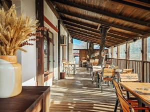 a porch of a restaurant with tables and chairs at Hotel Simeria in Gura Humorului