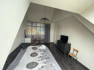 una camera con un grande letto e una televisione di Aux portes du Circuit a Mulsanne