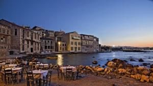 a group of tables and chairs next to a body of water at Studio Victory Chania in Chania