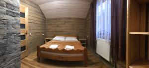 Cette petite chambre comprend un lit et une fenêtre. dans l'établissement Гірські будиночки, à Zhdenievo