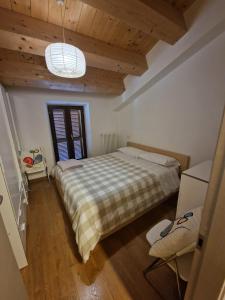 a bedroom with a bed with a checkered blanket at Grazioso Bilocale a 5 minuti da Numana in Numana
