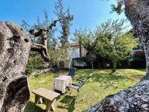 a backyard with a table and a bench and a tree at Ares Apartment - Vicino al Lago di Garda e alla Stazione Treno in Desenzano del Garda