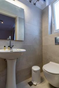 a bathroom with a sink and a toilet and a mirror at Manto Hotel in Mikonos