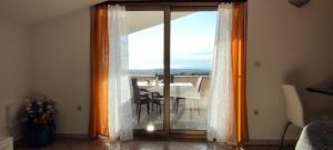 een kamer met een glazen schuifdeur en een eettafel bij Apartment Lorena in Kaštelir