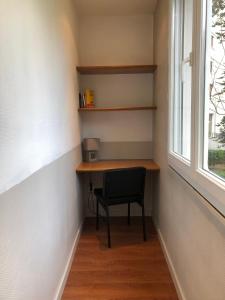 uma secretária num quarto com uma cadeira ao lado de uma janela em Studio 96 - Wi fi fibre - Résidence Beauséjour - Proche centre ville em Troyes