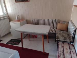 um quarto com uma mesa e um sofá e uma mesa e cadeira em Studio apartman Nina em Kraljevica