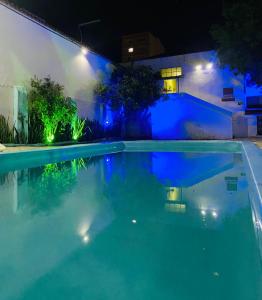 una piscina por la noche con luces azules en Hotel Planalto, en Poços de Caldas