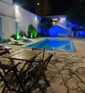 a patio with chairs and a swimming pool at night at Hotel Planalto in Poços de Caldas