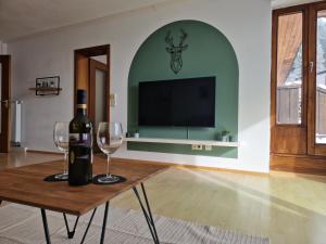 Habitación con mesa con 2 copas de vino y TV. en Große Terrasse, Netflix, 5min zum Skilift, 6 Personen, Waldnah, en Schonach