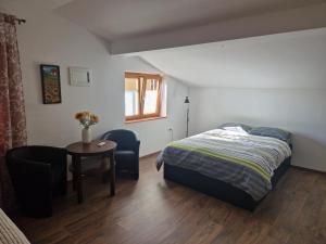 1 dormitorio con 1 cama, mesa y sillas en GuestHouse Flora en Koper