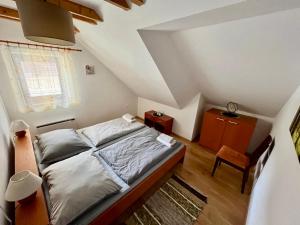 1 dormitorio pequeño con 1 cama y 1 silla en Apartmán Linda Tále, en Tale