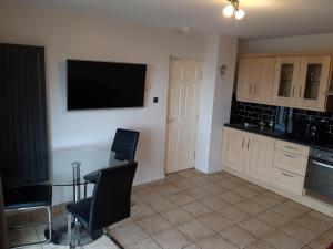 a kitchen with a table and a television on the wall at Atlantic View in Bundoran
