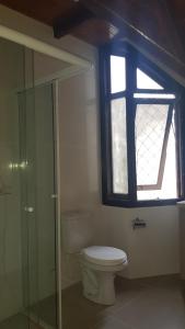 a bathroom with a toilet and a window at Chalé JS in São Bento do Sul