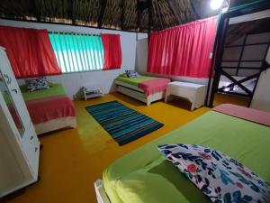 サン・ベルナルド・デル・ビエントにあるAntara del Marのベッド2台とカラフルなカーテンが備わる客室です。