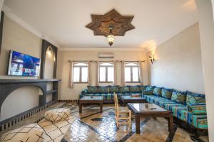 a living room with a couch and a table at Riad Jouba in Merzouga