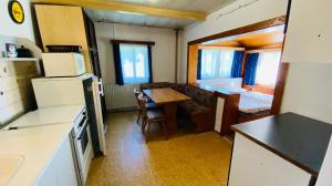 a kitchen with a table and a room with a bed at Horska chata Kristynka in Kořenov