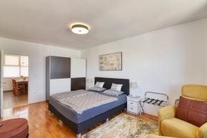 a bedroom with a bed and a couch and a chair at Studio Apartment Harbour Pula in Pula