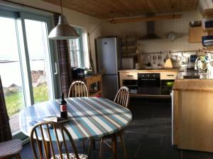 a kitchen with a table and chairs and a refrigerator at Pier Cottage, Applecross in Applecross