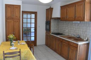 a kitchen with wooden cabinets and a table with a yellow table cloth at Villa Naladijo 6 People heated swimming pool games 650m city center in Saint-Didier