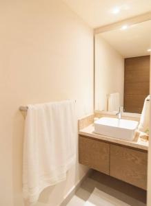 a bathroom with a white sink and a mirror at Ground level Garden condo at Akumal south by TAO Santamar in Akumal