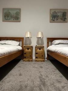 2 łóżka pojedyncze w pokoju z 2 stolikami nocnymi w obiekcie Trawsfynydd Stone Cottage w mieście Trawsfynydd
