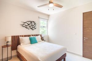 1 dormitorio con 1 cama y ventilador de techo en Ground level Garden condo at Akumal south by TAO Santamar en Akumal