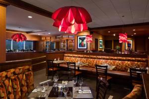 un restaurante con mesas, sillas y lámparas de araña rojas en Sheraton Springfield Monarch Place Hotel en Springfield