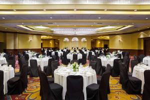un salón de banquetes con mesas blancas y sillas negras en Sheraton Springfield Monarch Place Hotel, en Springfield