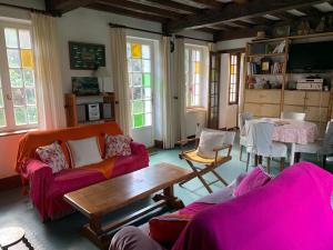 - un salon doté d'un mobilier rose et d'une table dans l'établissement La Flore Marine, à Saint-Jouin-Bruneval