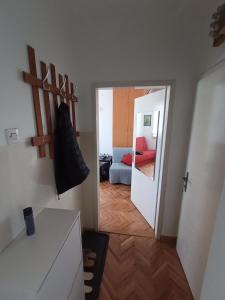 einen Flur mit einem Zimmer mit einem Bett und einem Spiegel in der Unterkunft Apartman Natalija in Kuršumlija