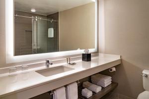 a bathroom with a sink and a mirror and towels at Fort Lauderdale Marriott Coral Springs Hotel & Convention Center in Coral Springs